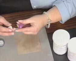 Hands are holding purple and white molding compounds.